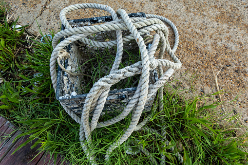 Piney Point, Maryland, USA A mooring line or rope lays outside of an old milk crate in a rural  marina.