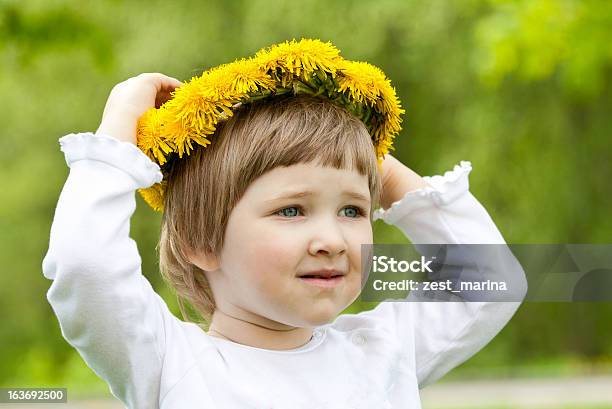 Little Girl Tratando Sobre Amarillo Chaplet Hecho De Dandelions Foto de stock y más banco de imágenes de 2-3 años