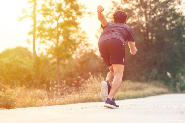 istock Athlete runner feet running on road, Jogging concept at outdoors. Man running for exercise with sunlight. 1637089020