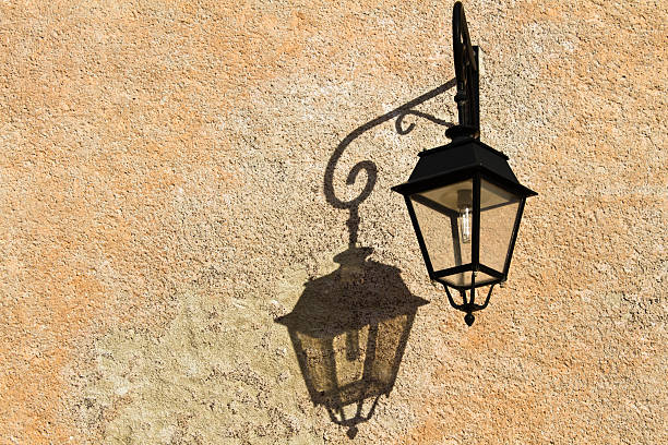 istock Wrought-iron lantern with its shadow on the yellow wall 163712109