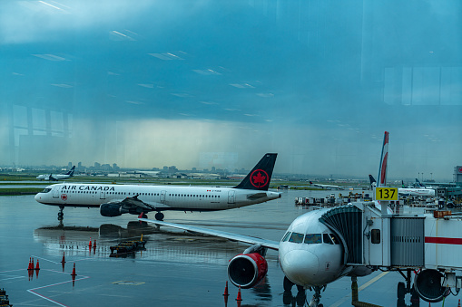 Toronto, Canada - July 25, 2023: An airplane of Air Canada is waiting passage for boarding at the terminal of Toronto Pearson International Airport, Mississauga, Canada.