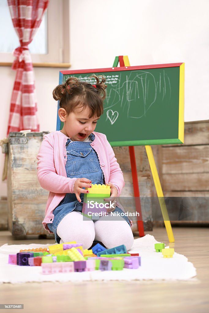 Petite fille jouant avec des cubes en plastique - Photo de 2-3 ans libre de droits