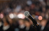 Audio microphone close up with audience in background