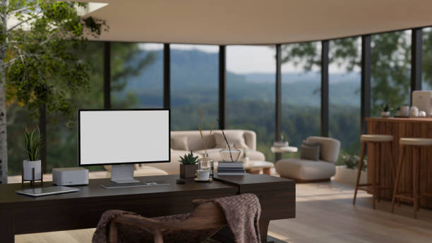 istock Home workspace with a computer on a table in a modern spacious living room with glass wall. 1637188996