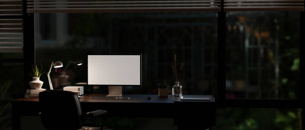 istock A modern office room at night with light from a table lamp, a computer mockup on a desk 1637189074