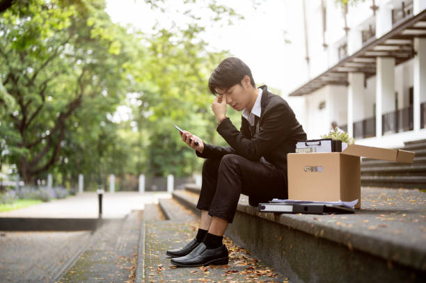 istock A stressed and upset Asian businessman sits on a staircase after getting fired or losing his job. 1637193176