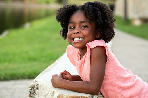 African American little girl smiling outside.