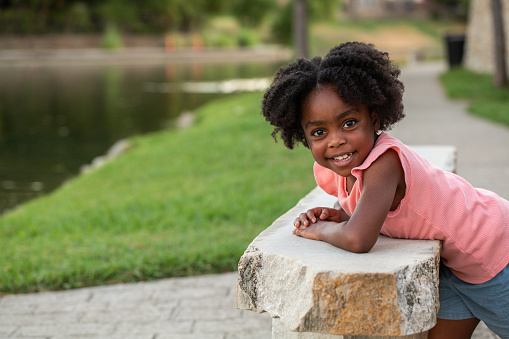 African American little girl smiling outside.