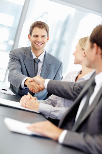 Young business man greeting colleague during meeting