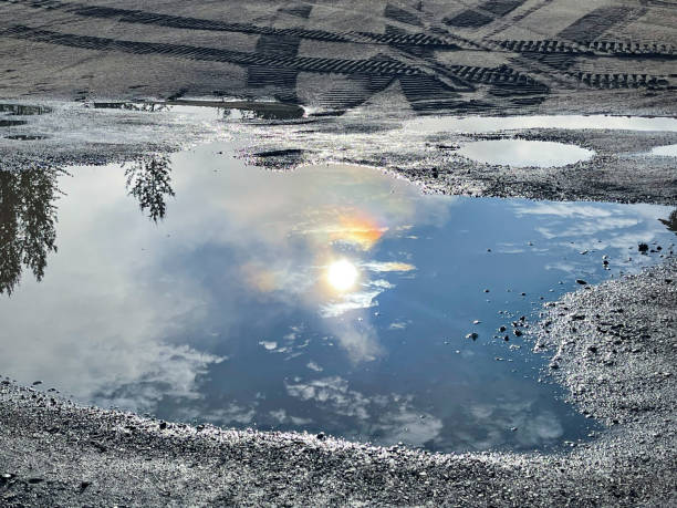 After a recent rain the morning sun is reflected upon a puddle of rain water