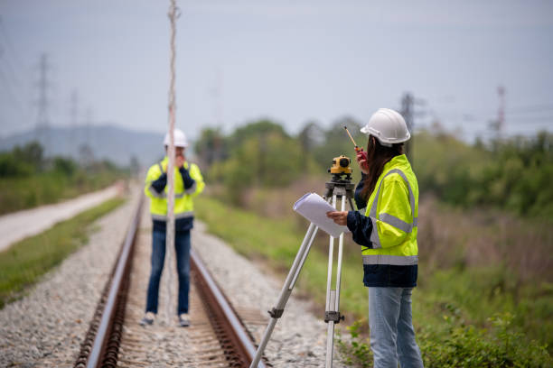 istock Surveyor engineers team wearing safety uniform,helmet and blueprint document checking inspection by theodolite to measurement position on railway construction site is industry transportation concept. 1637254894