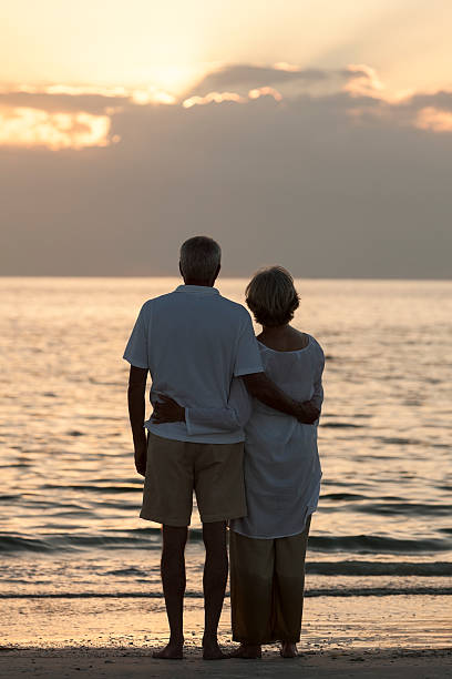 istock Senior Couple Embracing Sunset Tropical Beach 163728078