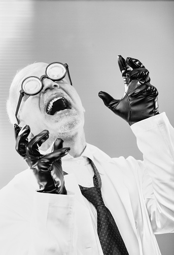 mad scientist, an iconic evil professor in outdated black and white, cackles madly at his wicked plan for world domination. Bald with thick glasses, he wears black leather gloves over his white coat.