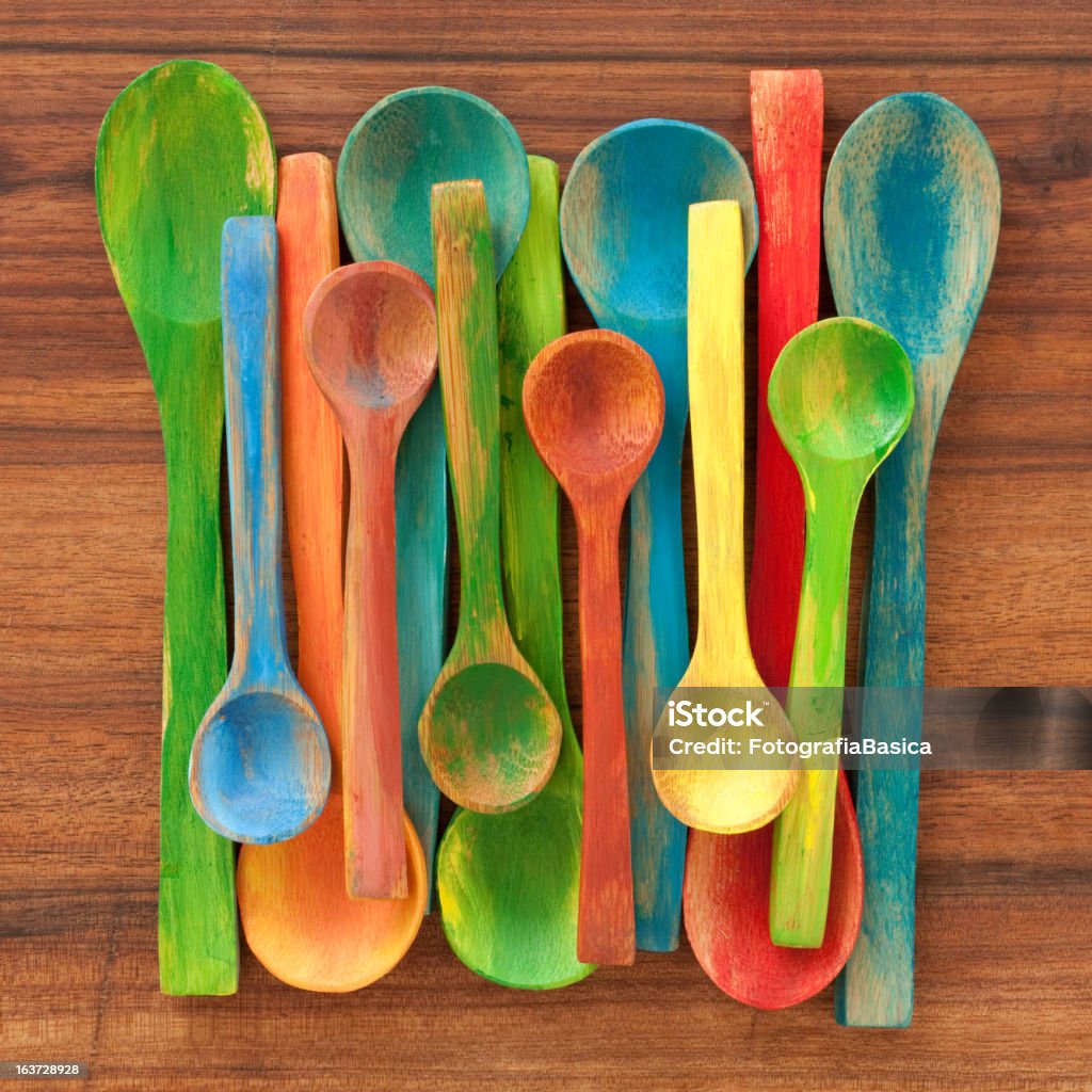 Painted spoons Several painted wooden spoons over wood Paint Stock Photo