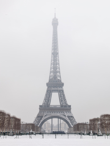 Image of the Eiffel Tower from Champs de Mars after the first night snowfall of the year in Paris.