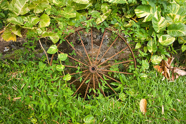 An old and broken agricultural wagon/carriage wheel leaning against a honey coloured stone wall. Ideal background image.Similar images:
