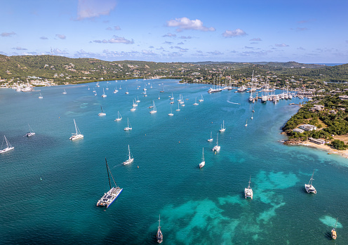 The drone aerial view of Deep Bay, Cherry Hill Bay Beach and Falmouth Harbour in Antigua Island.