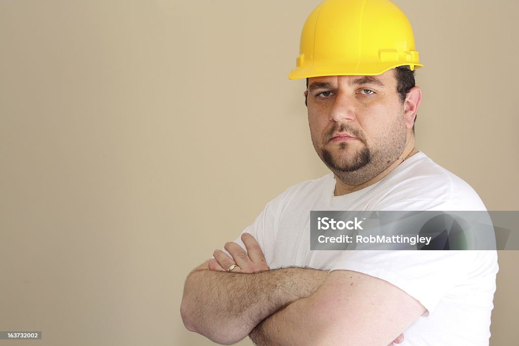 Construction Worker A large construction worker with a goatee looks at the camera with his arms crossed. 30-34 Years Stock Photo