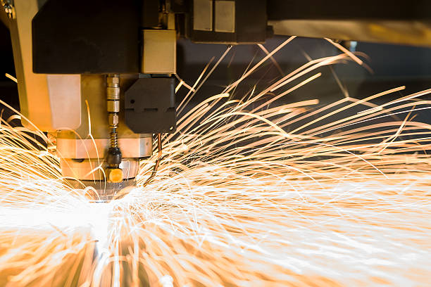 High-tech metal CNC, cutting laser tool in use. A photograph os a high-tech metal cutting laser tool in operation. laser cutting metal stock pictures, royalty-free photos & images