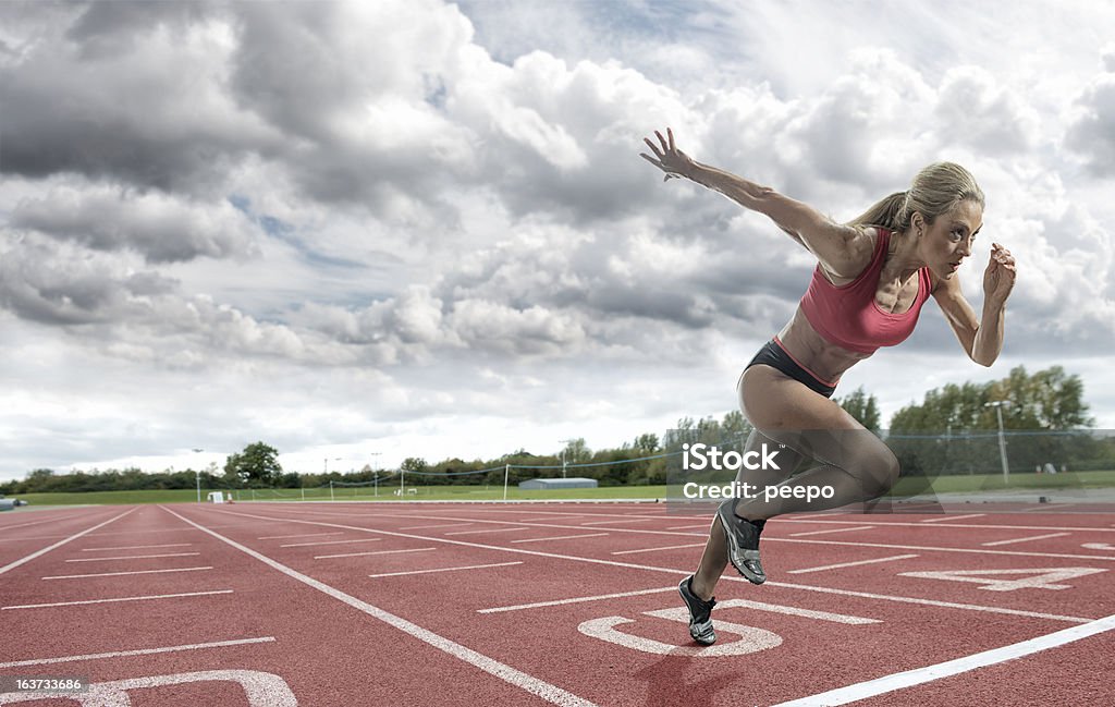 Jeune femme athlète décoller sur la piste de jogging - Photo de Femmes libre de droits