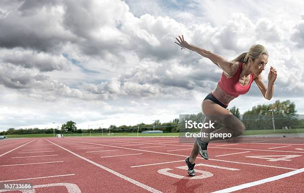 Jovem Atleta Descolar Em Uma Pista De Corrida - Fotografias de stock e mais imagens de Mulheres - Mulheres, Atletismo, Corrida de Velocidade