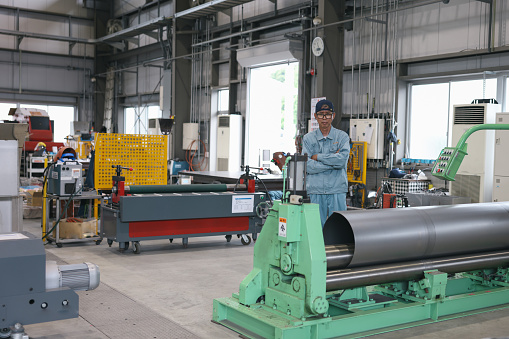 Asian Mature Male Industrial Worker Looking At Camera At Factory.
Professional Engineer Man confident and cool attitude.