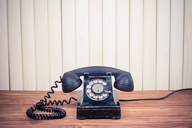 istock Vintage telephone on old table near wood wall 163736311