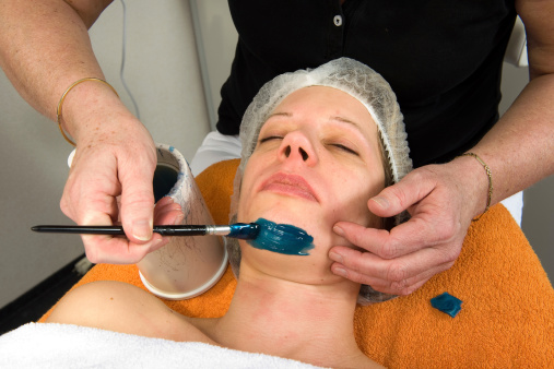 A woman's chin is being waxed in a beauty salon