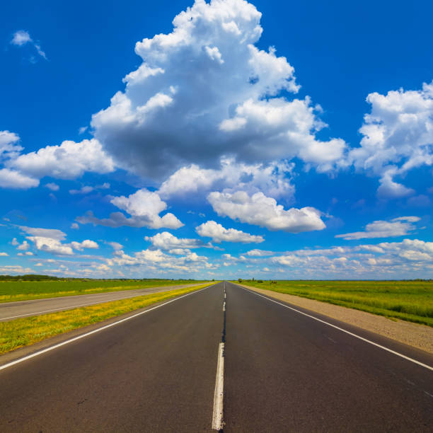 istock long asphalt road under blue cloudy sky 1637370375