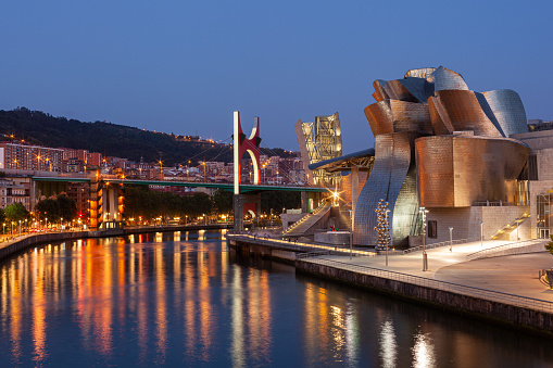Bilbao, Spain - August 02, 2022: Sunset view of modern and contemporary art Guggenheim Museum, designed by American architect Frank Gehry and inaugurated in October 1997.