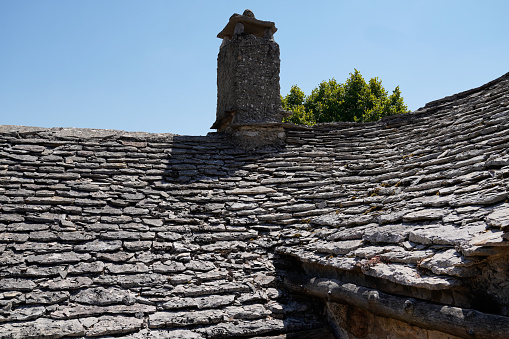 roof tiles stone grey from old house medieval building with chimney gray stones background