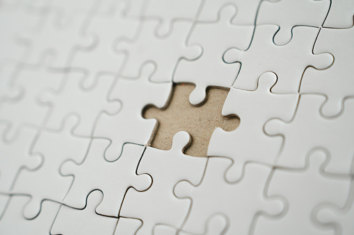 Close-up of shiny blank white jigsaw puzzle texture background.