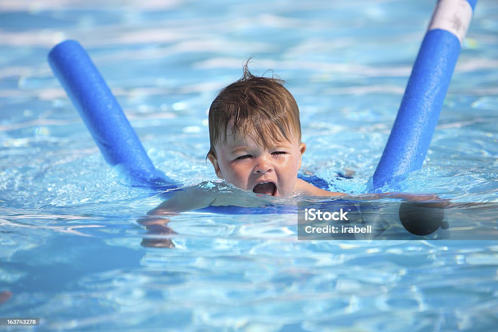 Feliz Garotinho aprendendo a nadar com piscina de macarrão - Foto de stock de Boia-espaguete royalty-free