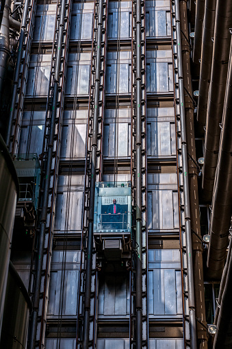 low angle view on the elevator of the office building of Lloyds of London, City of London United Kingdom. One businessman standing in the elevator.