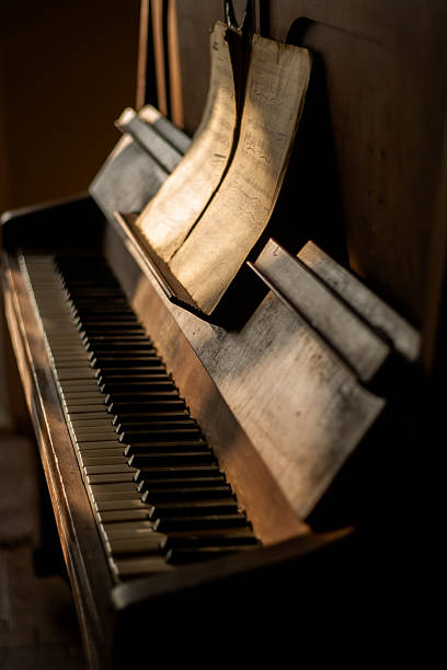 istock Antique piano with old music sheets in a sunlight 163745552