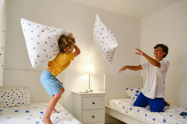 istock Happy boys fighting with pillows 1637465651