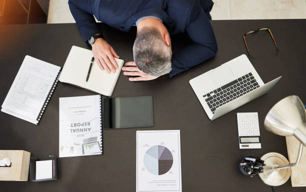 istock Business man, top view and sleep on desk, office or report with documents, notebook and laptop. Mature CEO, boss or leader with fatigue, paperwork or computer for audit, accounting and tired by table 1637476608