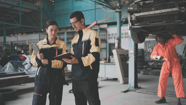 The insurance officer inspects the car to assess the cost of repairs.