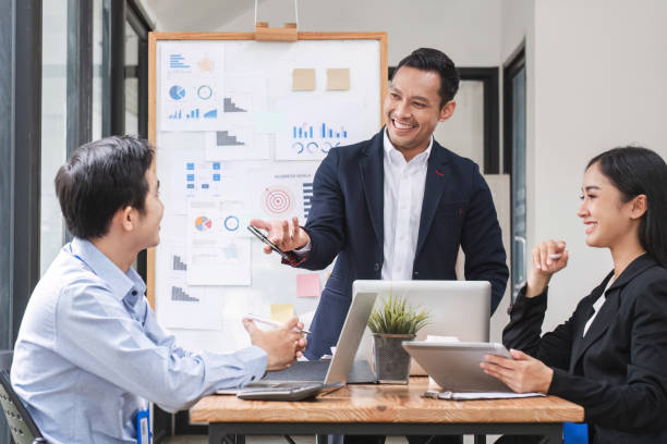 istock Professional businessman presenting to colleagues in conference room explaining growth chart 1637498868