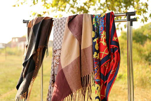 An assortment of colorful handkerchiefs hangs on a stand.