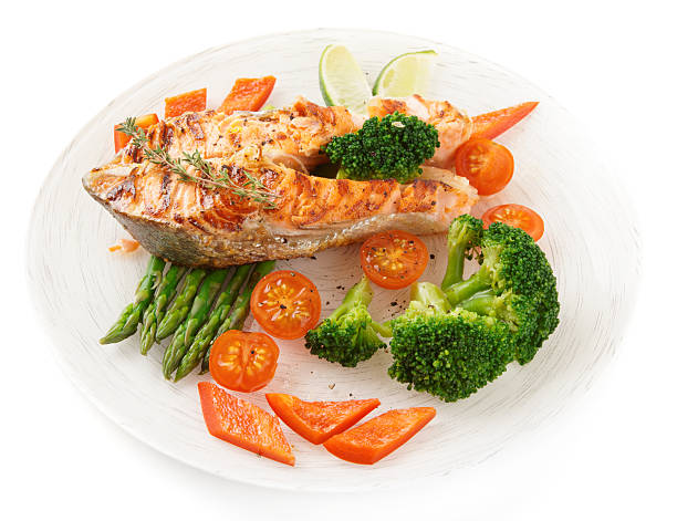 istock Salmon steak with vegetables in plate isolated on white 163751392