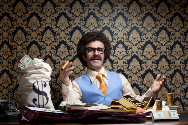 Rich man posing with money bags, gold bullions, dollar bills Horizontal photo of rich man posing with money bags, gold ingots and dollar bills and sitting on table.He has long hair and mustache and wearing a blue waist and a yellow necktie.Wallpaper is on the background.Model is holding cigar in right hand.Vignette light effect achieved during shot.Full frame DSLR camera was used. man cigar stock pictures, royalty-free photos & images