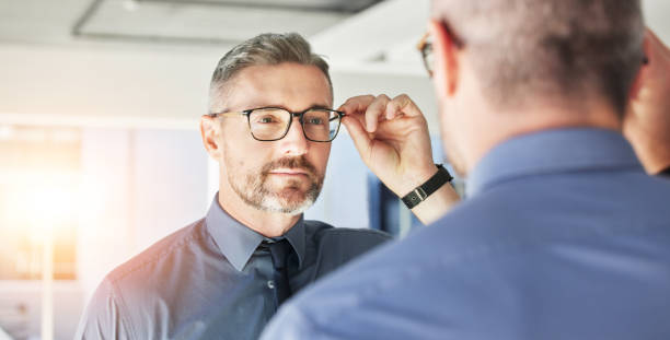 istock Mirror reflection, optometry and man with glasses for eye care, vision and choice of frame. Mature, store and person eyewear shopping for a lens or fit for eyeglasses style in a shop with a decision 1637547067