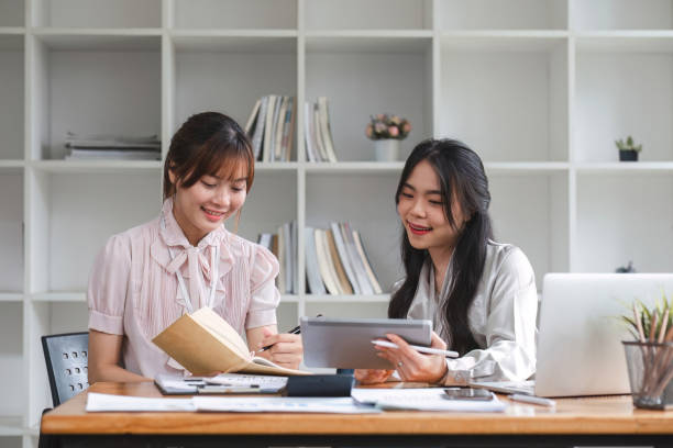 istock Two Young Asian businesswoman discuss with new startup project Idea presentation, analyze statistics and investment market at office 1637556957