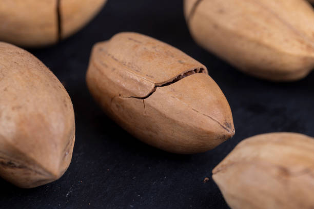 istock cracked unpeeled pecans close-up on the table 1637559824