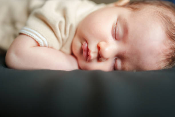 istock Little baby boy is sleeping on his cheek. 1637562729