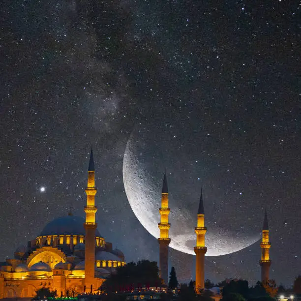 Suleymaniye Mosque and crescent moon with Milky Way image. Islamic or ramadan or Eid or kandil or laylat al-qadr concept image.