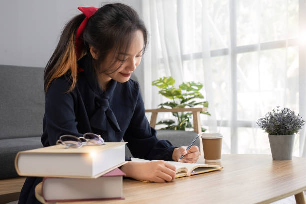 istock Close up young woman of Asian write down memories in notebook diary, work homework 1637576929