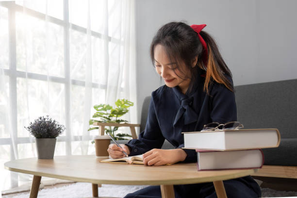 istock Close up young woman of Asian write down memories in notebook diary, work homework 1637577510
