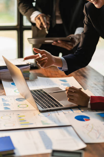 istock Business team meeting using calculator Working with laptop and charts and analyzing business strategy Financial statistics sitting at the table in the financial office in vertical view 1637591159